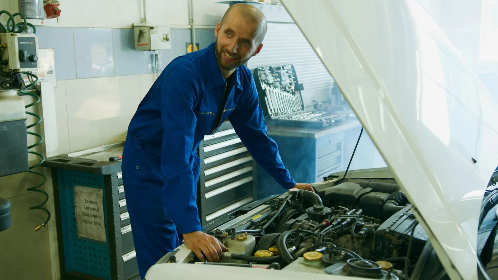 Technician working under the hood of a vehicle