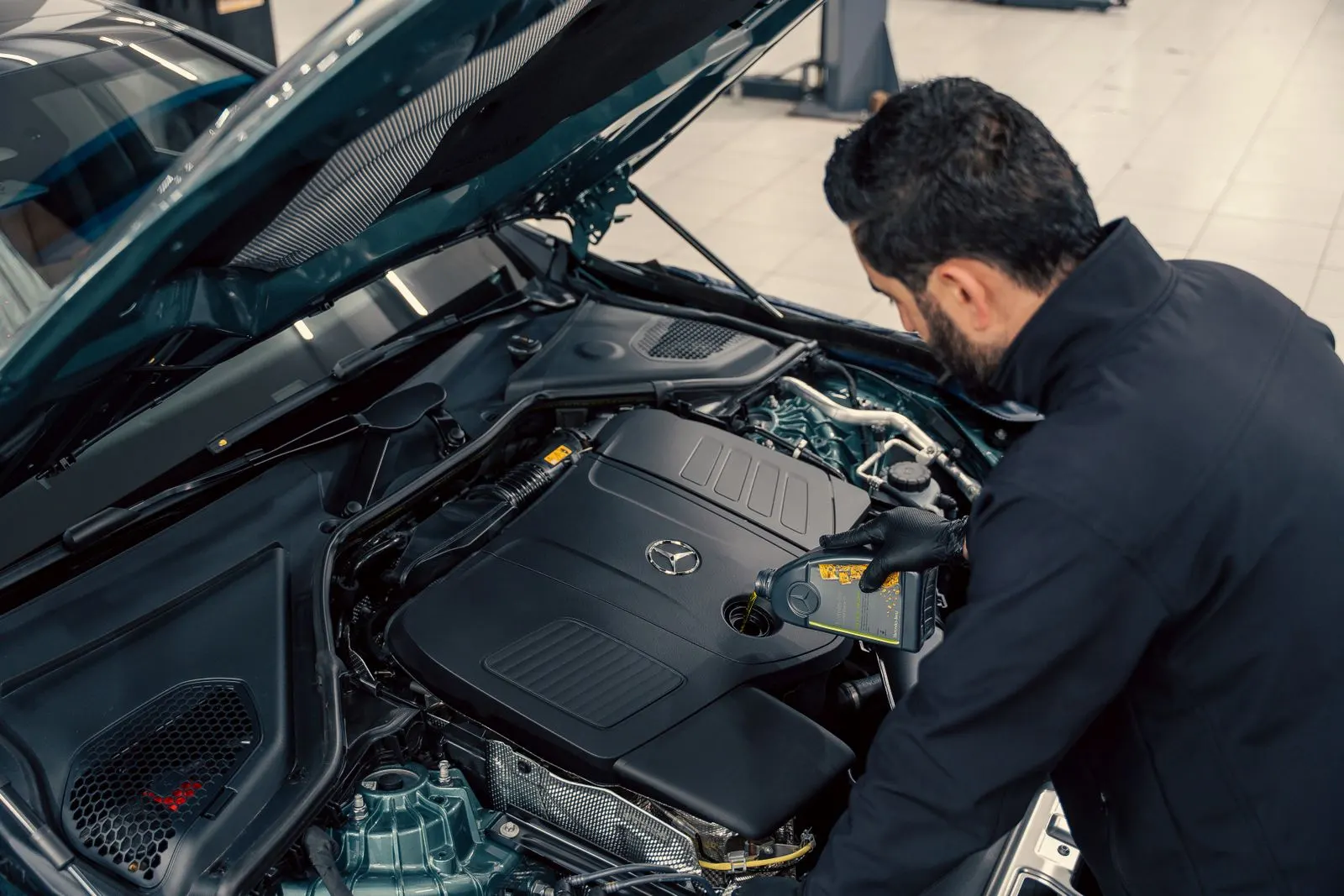 Technician checking engine oil level at a service center